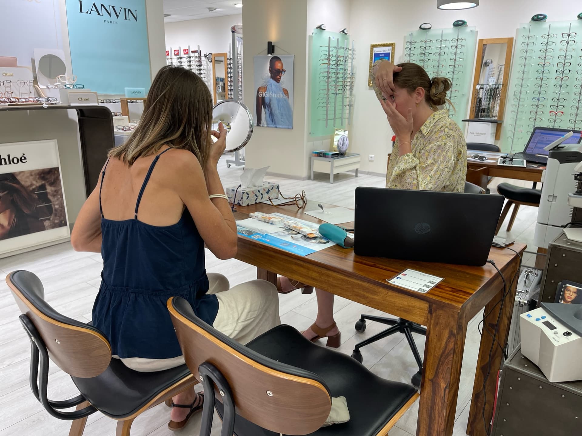 Une opticienne montre à une cliente comment mettre sa lentille